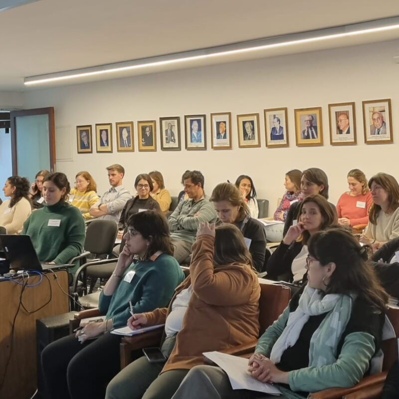 Personas sentadas en un anfiteatro atento al discurso de la oradora.