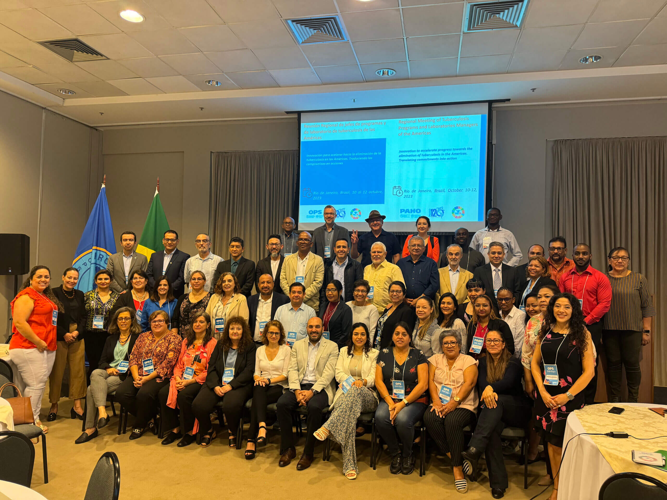 Foto grupal de todos los participantes del evento en el escenario del mismo, en el evento "Innovación para avanzar hacia la eliminación de la tuberculosis en las Américas tratamiento".