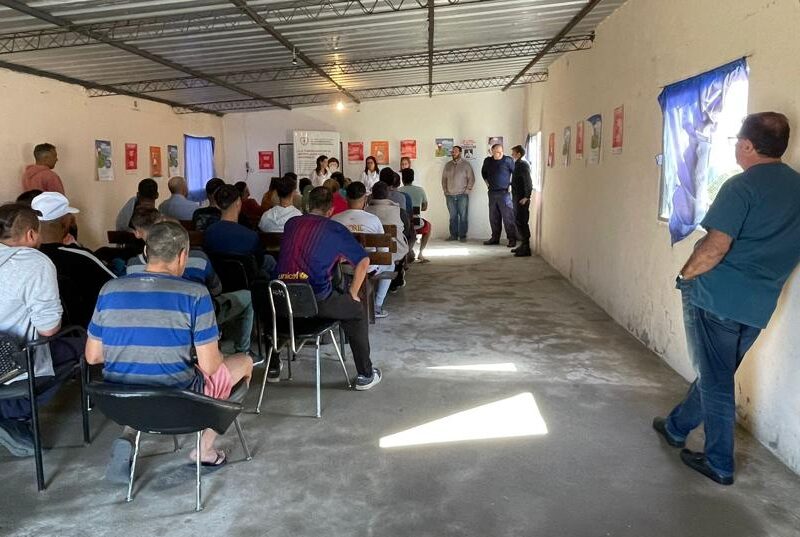 Personas sentadas en un salón atento al discurso de la oradora.